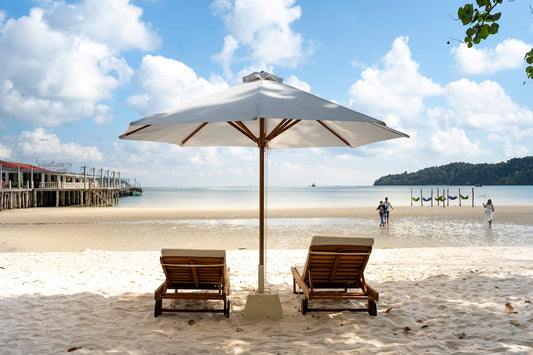 a couple of chairs sitting under an umbrella on a beach